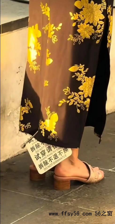 女子穿着带有巨大吊牌旗袍街头拍照